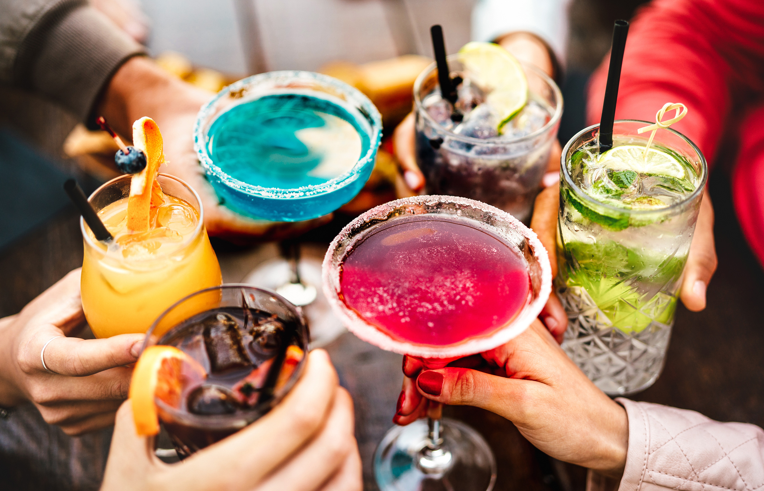 Featured image: Hero image close-up of toast with variety of tropical drinks